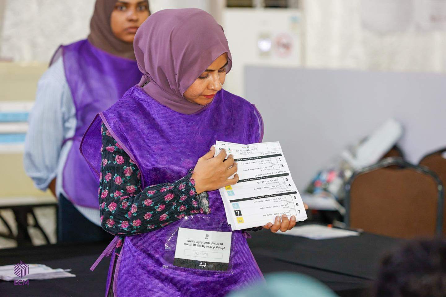 ލޯކަލް އިންތިޚާބުގައި އޮފިޝަލަކު ވޯޓު ކަރުދާސް ދައްކާލަނީ، ފޮޓޯ؛ އީސީ