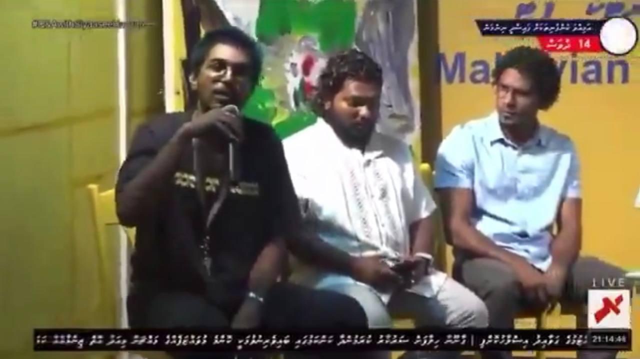 އެމްޑީޕީގެ ހަރުކާތުގައި މަސްތުގެ ހާލުގައި އިނދެ އެމީހާ ވާހަަކަ ދައްކަނީ، ފޮޓޯ:ރާއްޖެ ޓީވީގެ ލައިވުން ނަގާފައިވާ ސްކްރީންޝޮޓެއް
