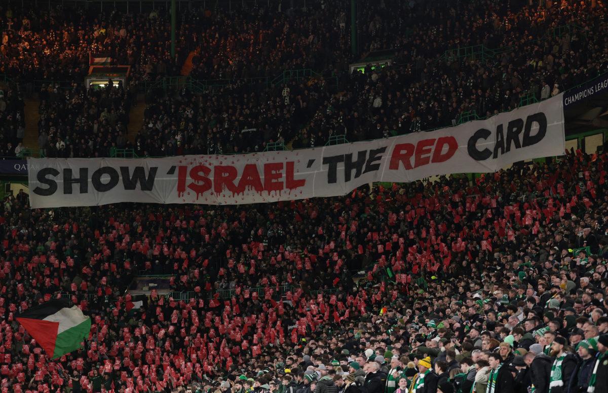 Soccer Football - Champions League - Knockout Phase Playoff - First Leg - Celtic v Bayern Munich - Celtic Park, Glasgow, Scotland, Britain - February 12, 2025
A Palestine flag is seen as Celtic fans display a banner stating 'show Israel the red card' amid a ceasefire between Israel and Hamas Action Images via Reuters/Lee Smith